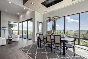 Dining space featuring plenty of natural light, a mountain view, hardwood / wood-style floors, a towering ceiling, and recessed lighting