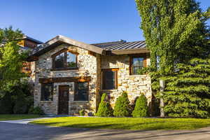 View of front of home with stone siding, a standing seam roof, and metal roof