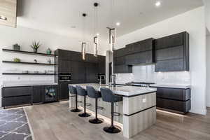 Kitchen with a kitchen breakfast bar, modern cabinets, light wood-type flooring, light countertops, and open shelves