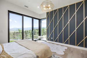 Bedroom featuring a chandelier, a mountain view, wood finished floors, recessed lighting, and access to outside