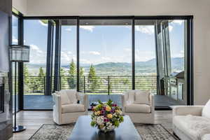 Living area with a mountain view, plenty of natural light, wood finished floors, and a high end fireplace
