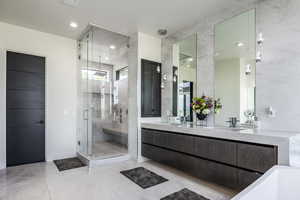 Full bathroom with a stall shower, double vanity, and tile patterned floors