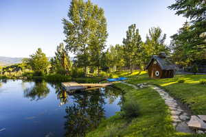 Dock area with a lawn and a water and mountain view