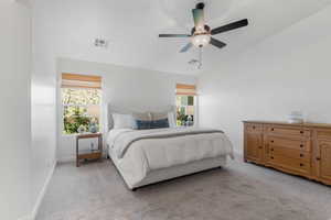 Carpeted bedroom with ceiling fan and lofted ceiling