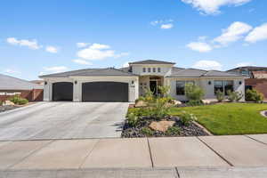 View of front of house featuring a garage and a front lawn