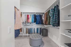 Spacious closet with carpet floors and vaulted ceiling