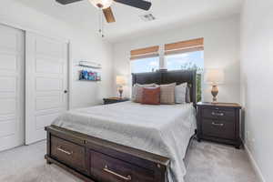 Bedroom with light carpet, a closet, and ceiling fan