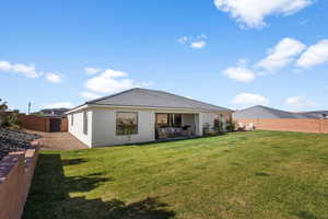 Rear view of house featuring a patio area and a yard