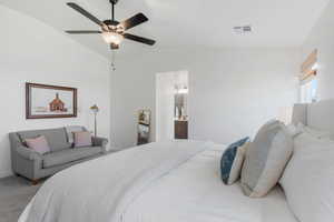 Bedroom with lofted ceiling, connected bathroom, carpet floors, and ceiling fan