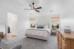 Bedroom featuring multiple windows, light carpet, and ceiling fan