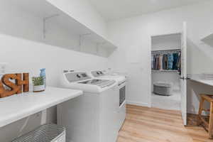 Laundry area featuring washer and dryer and light wood-type flooring