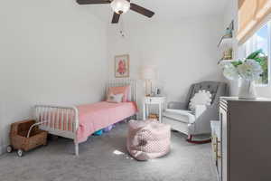 Carpeted bedroom featuring ceiling fan