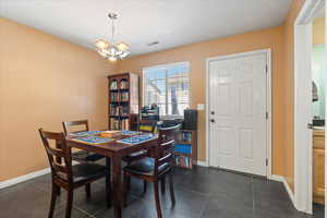 Tiled dining space with a notable chandelier