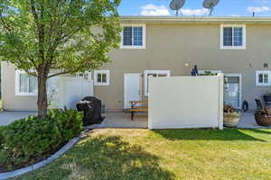 Rear view of house featuring a patio and a lawn