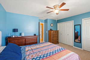 Bedroom with light carpet, a closet, and ceiling fan