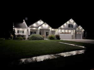 View of front of property with a garage and a lawn