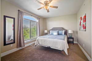 Carpeted bedroom featuring ceiling fan