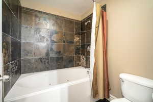 Bathroom with shower / tub combo and toilet