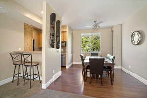 Dining space with dark hardwood / wood-style flooring and ceiling fan