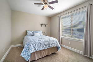 Carpeted bedroom with ceiling fan