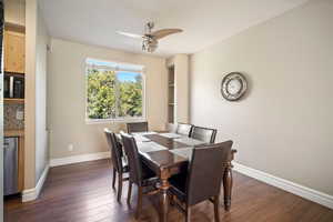 Dining space with dark wood-type flooring and ceiling fan