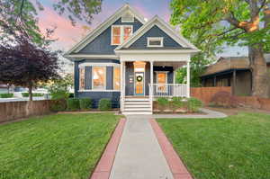 View of front of home with a porch and a yard