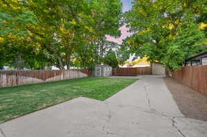 Yard at dusk featuring a patio and a storage unit