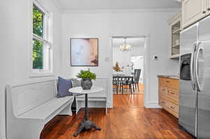 Interior space with a notable chandelier, stainless steel refrigerator with ice dispenser, a wealth of natural light, and dark hardwood / wood-style floors