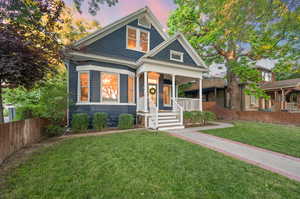 View of front facade featuring a porch and a yard