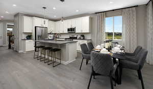 Kitchen featuring appliances with stainless steel finishes, white cabinets, and LVT flooring. This is a picture of the model home; selections and colors may vary.