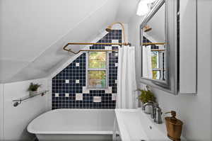 Bathroom with shower / bath combo with shower curtain and lofted ceiling