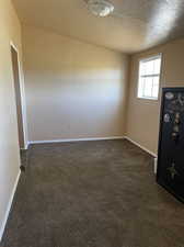 Carpeted empty room featuring a textured ceiling