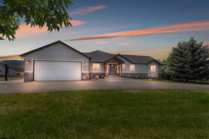 View of front of property featuring a garage and a yard