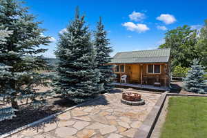 View of front of home featuring an outbuilding and a fire pit