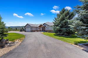 Single story home featuring a garage and a front lawn