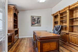 Office area featuring dark wood-type flooring and vaulted ceiling