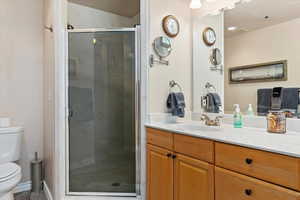 Bathroom with vanity, an enclosed shower, tile patterned flooring, and toilet