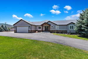 Ranch-style home featuring a garage and a front yard