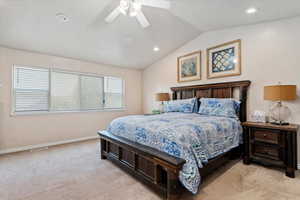 Bedroom featuring light carpet, vaulted ceiling, and ceiling fan