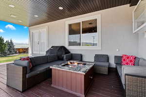 Wooden terrace with an outdoor living space with a fire pit