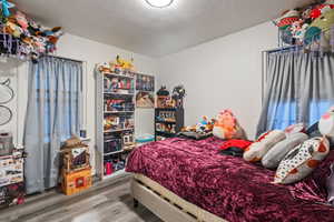 Bedroom featuring a textured ceiling and hardwood / wood-style flooring