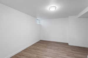 Basement featuring a textured ceiling and wood-type flooring