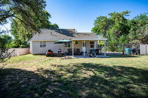 Rear view of property with a patio and a yard