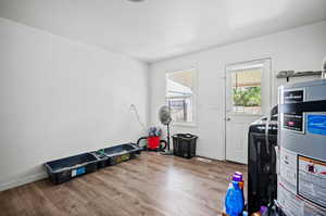 Exercise room with light wood-type flooring and water heater