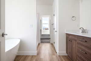 Bathroom featuring vanity, hardwood / wood-style flooring, and a bathtub