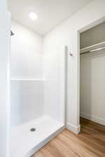 Bathroom featuring a shower, wood-type flooring, and a textured ceiling