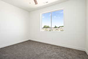 Carpeted spare room featuring ceiling fan