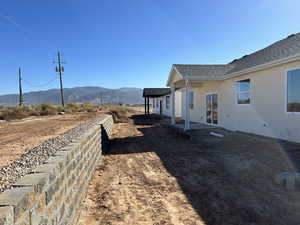 View of side of property with a mountain view and a patio area