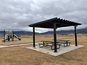 Surrounding community with a mountain view, a yard, and a playground