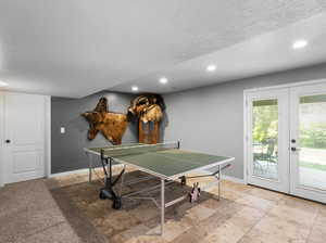 Playroom featuring a textured ceiling, french doors, and light tile patterned floors